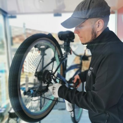 serwisant naprawaia rower podczas wyjazdowego serwisu rowerowego dla firm.