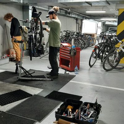 bike day podczas w parkingu podziemnym i mobilnyy serwis rowerowy. Pracownicy z rowerami serwisujący rowery.