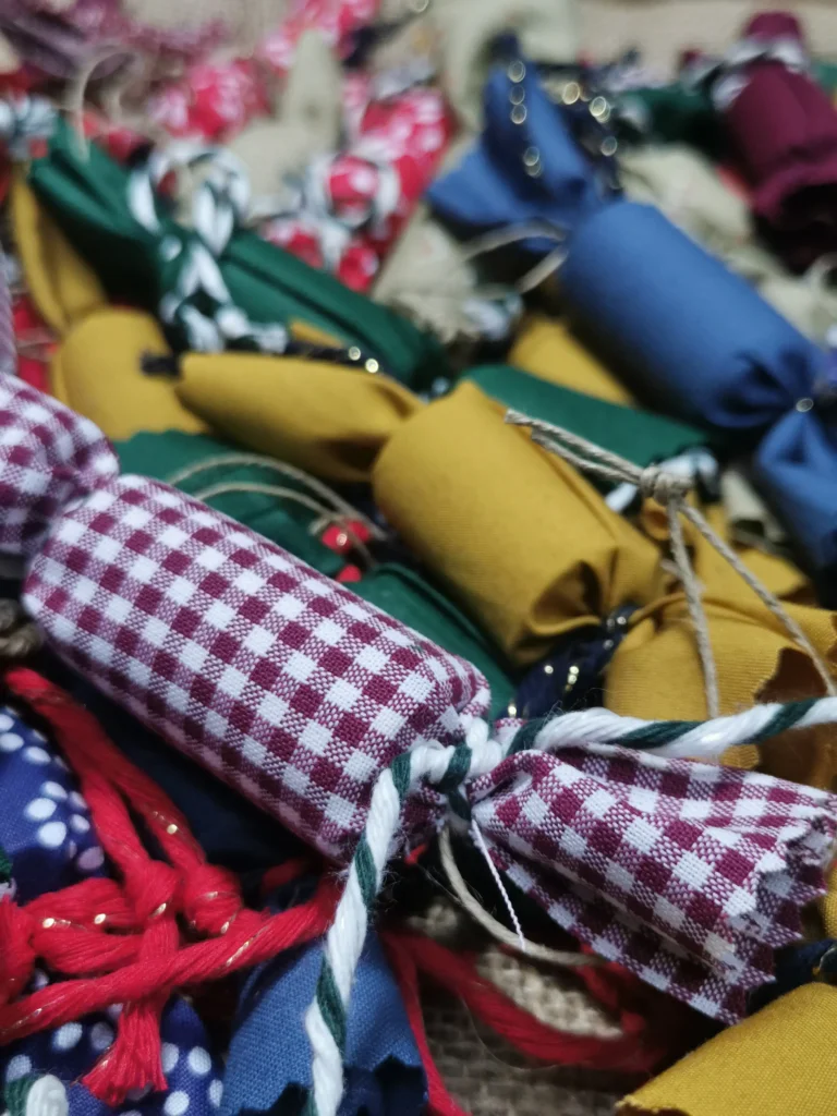świąteczne ozdoby, ekologiczne podczas warsztatów dla dzieci. Zapakowane cukierki w materiał z upcyclingu. zbliżenie na cukierek